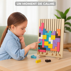 Enfant plaçant un bloc sur le plateau posé sur la table